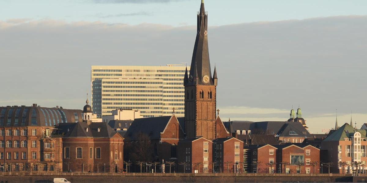 Ansicht der Lambertuskirche vom gegenüberliegenden Rheinufer aus.