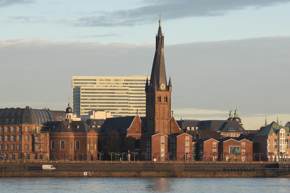 Ansicht der Lambertuskirche vom gegenüberliegenden Rheinufer aus. (c) Beatrix Reese Ansicht der Lambertuskirche vom gegenüberliegenden Rheinufer aus.
