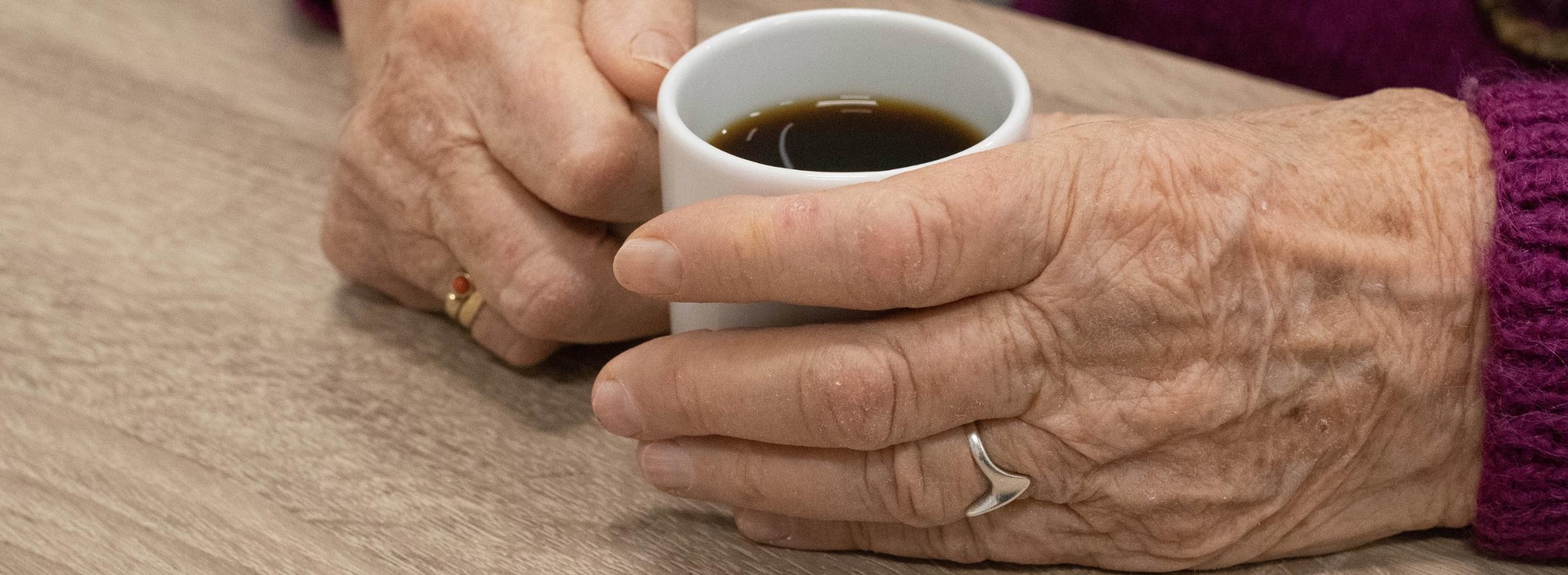 Seniorenkreise alte Hände halten eine Kaffeetasse in der Hand