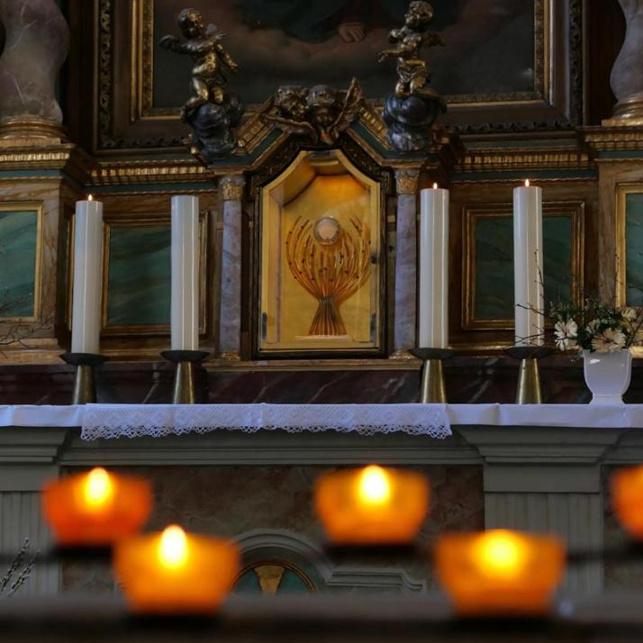 Kerzen brennen vor der Monstranz mit Allerheiligsten in der Andreaskirche.