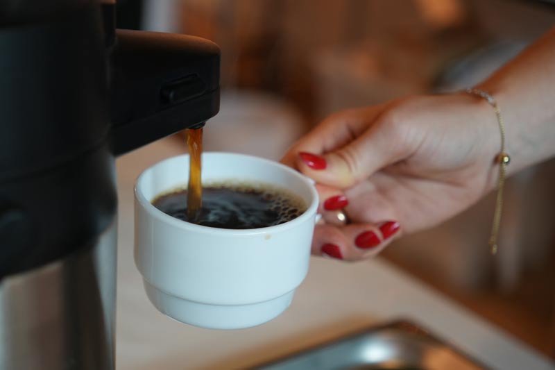 Kaffee wird aus einer Thermoskanne gezapft