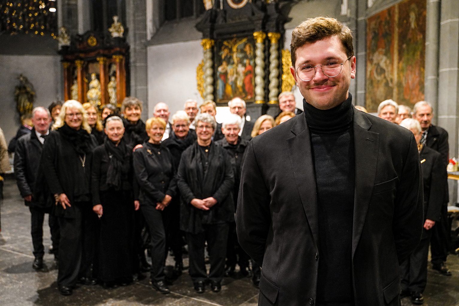 Kantor Johannes Güdelhöfer und Sängerinnen und Sänger des Stiftschores